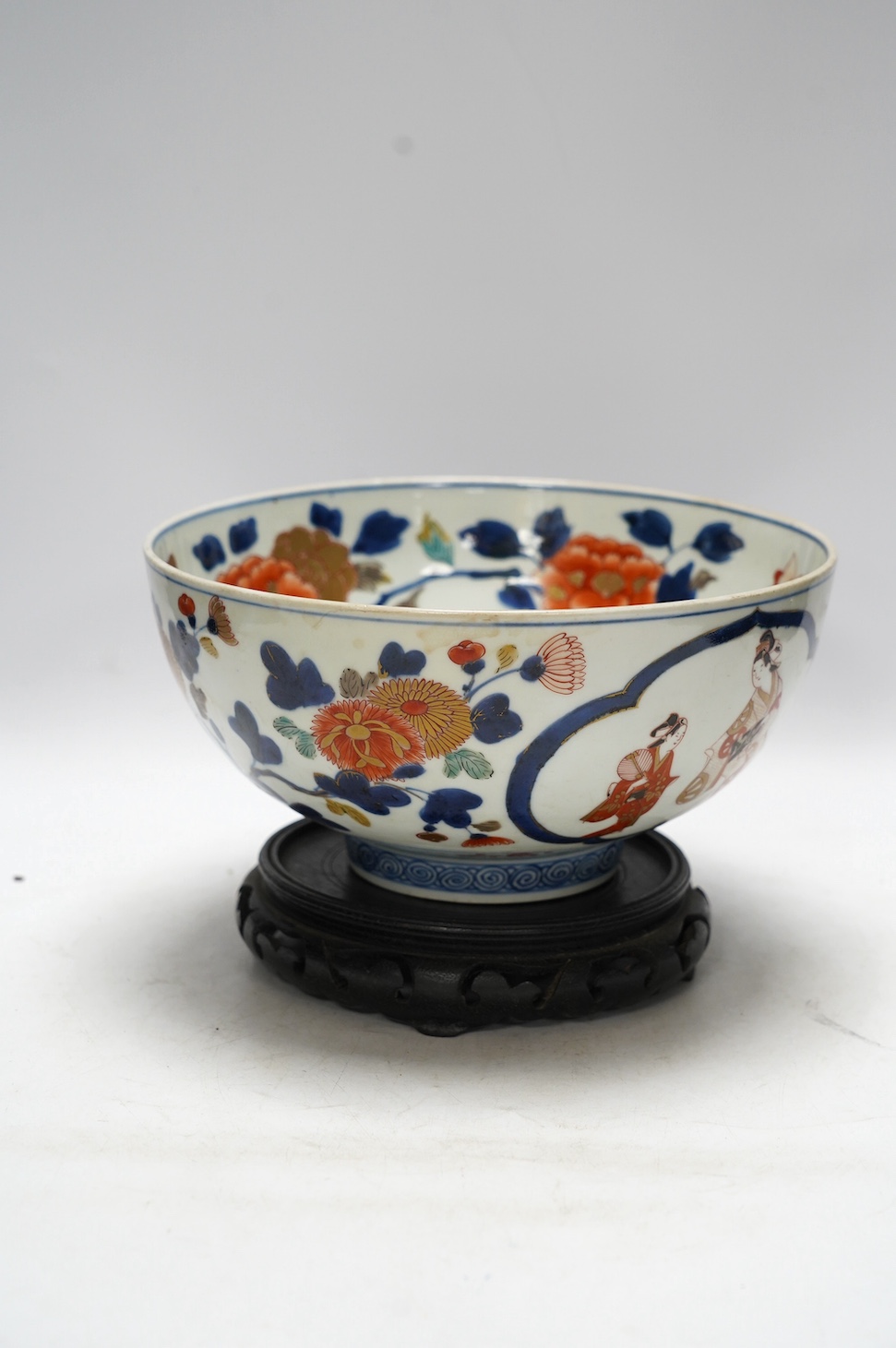 A Japanese Arita polychrome bowl, c.1700, diameter 24.5cm, height 12.5cm, on a carved hardwood stand. Condition - large overglazed open firing crack to foot, otherwise good